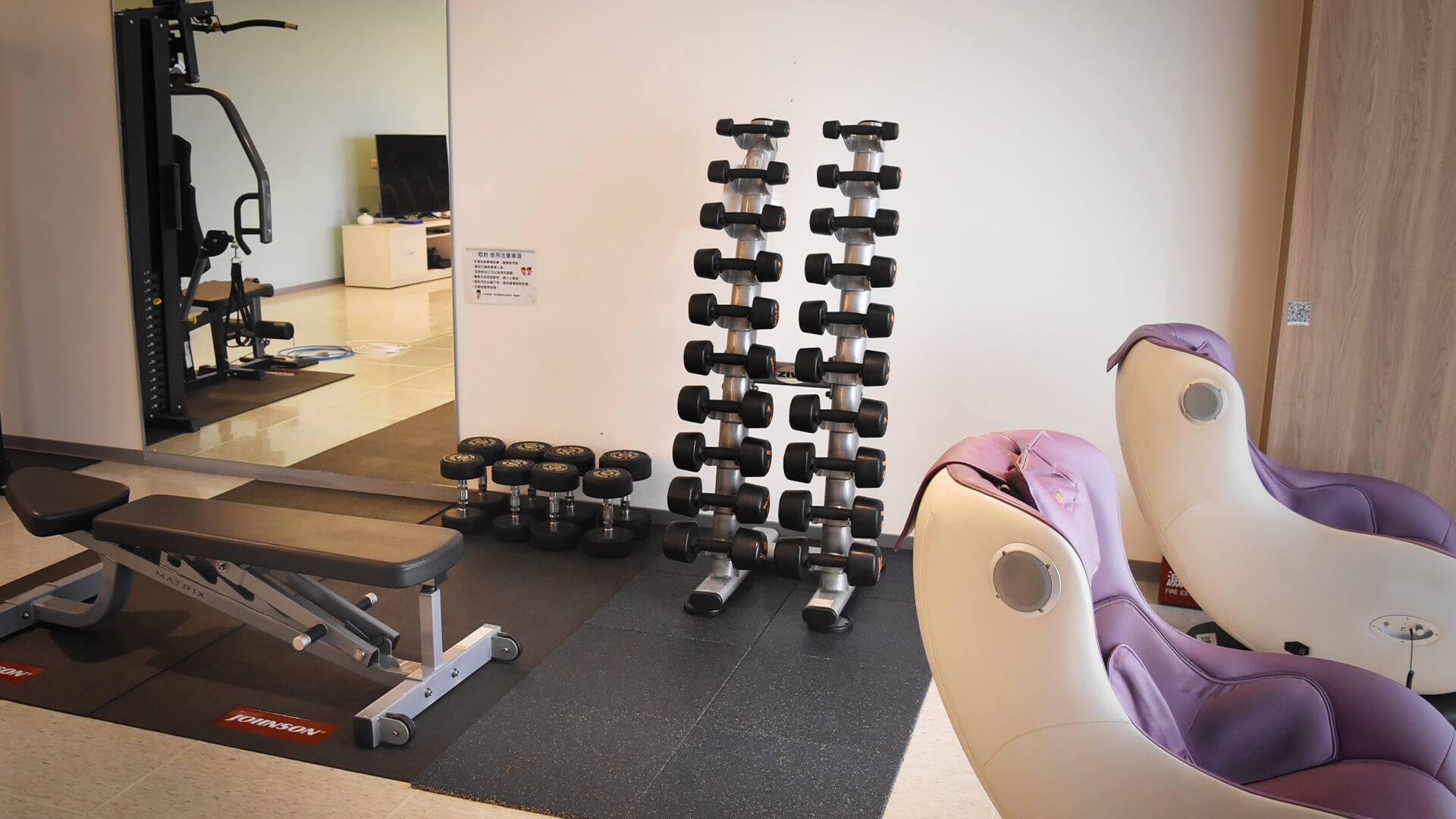 Office wellness corner with dumbbell rack, bench and massage chairs