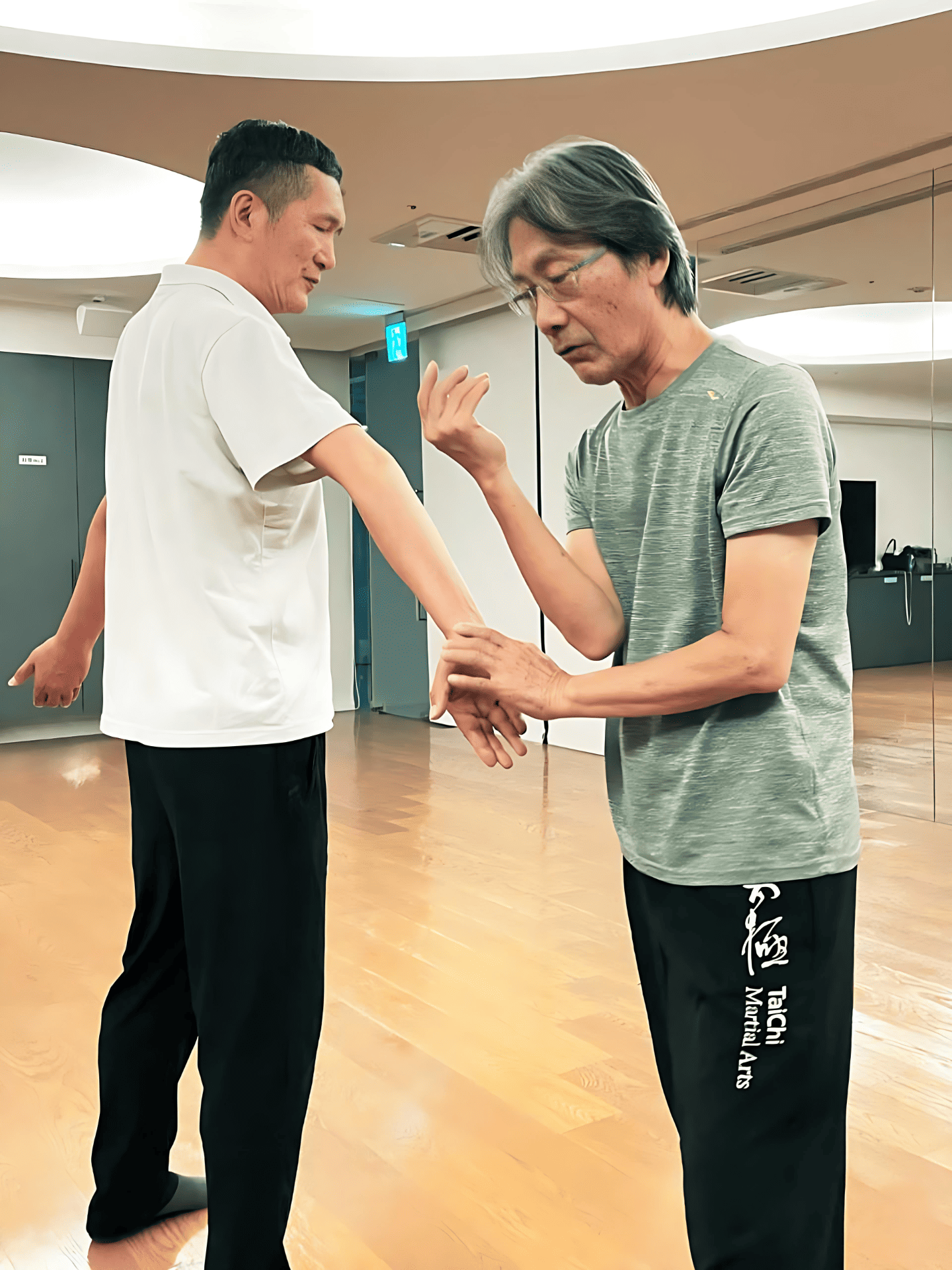 先生は生徒の太極拳の姿勢を矯正している